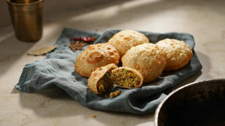 Atta kachoris with a blistered crust, one broken to show the dal filling, made with CressPure Sharbati atta