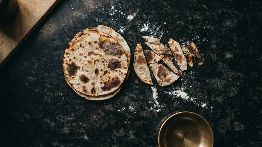 Thin crisp khakhras with a mottled roasted surface, one broken in half, made with CressPure Sharbati atta